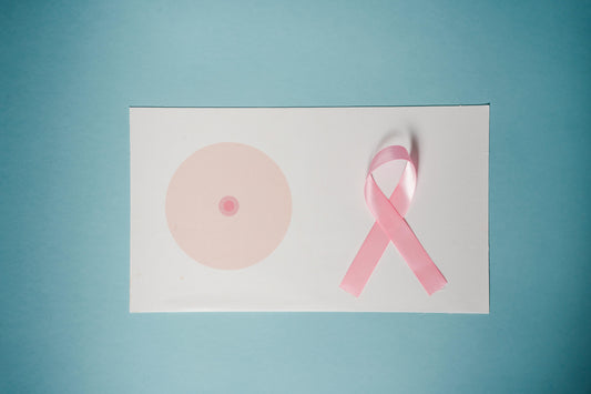 Pink breast cancer awareness ribbon next to a breast illustration, symbolizing breast cancer survivorship and exploring safe nonhormonal menopause support after treatment.